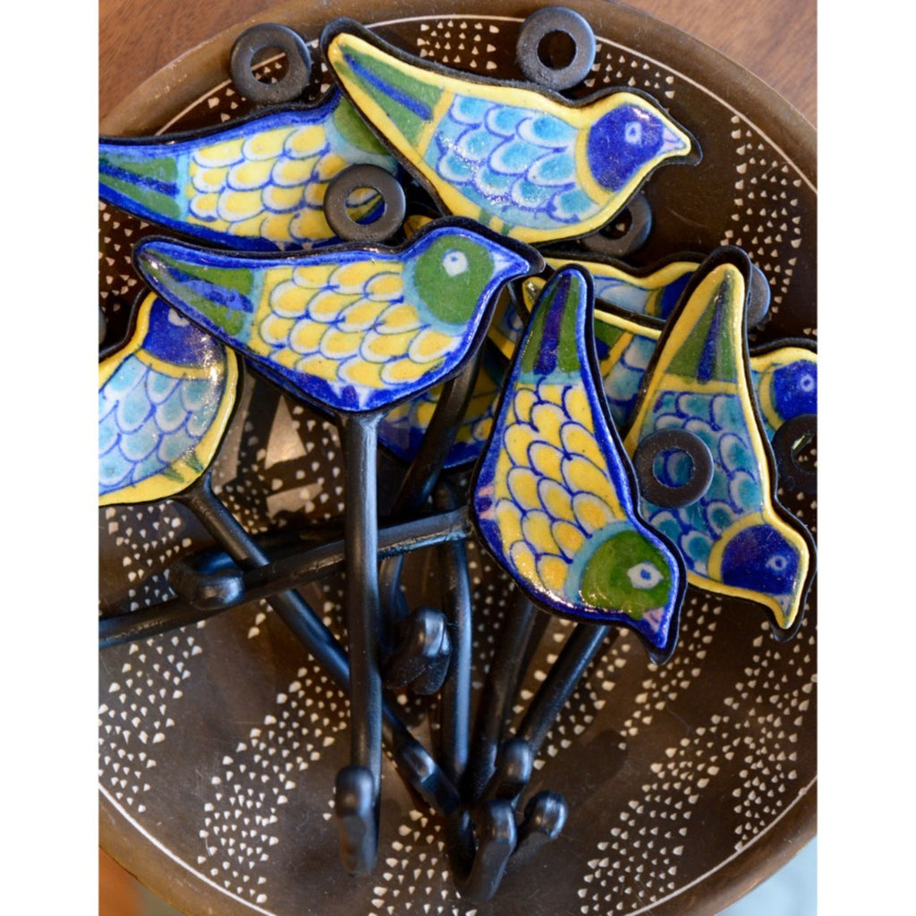 Blue Pottery Bird Robe Hooks, in blue, yellow, turquoise and green, in a brown bowl.