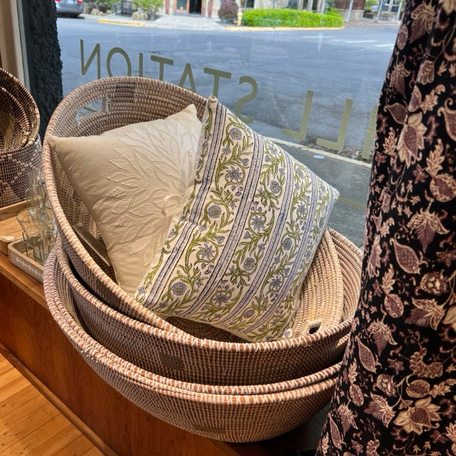 Giant floor hold-all Oval shaped Woven baskets with pillows in the shop window at Hill Station