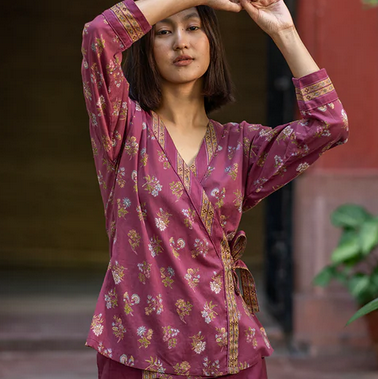 woman with arms raised by her face wearing a cotton crossover top