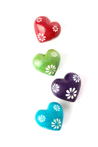 Collection of Colourful tiny rainbow colored soapstone hearts with white etched flowers, detail.
